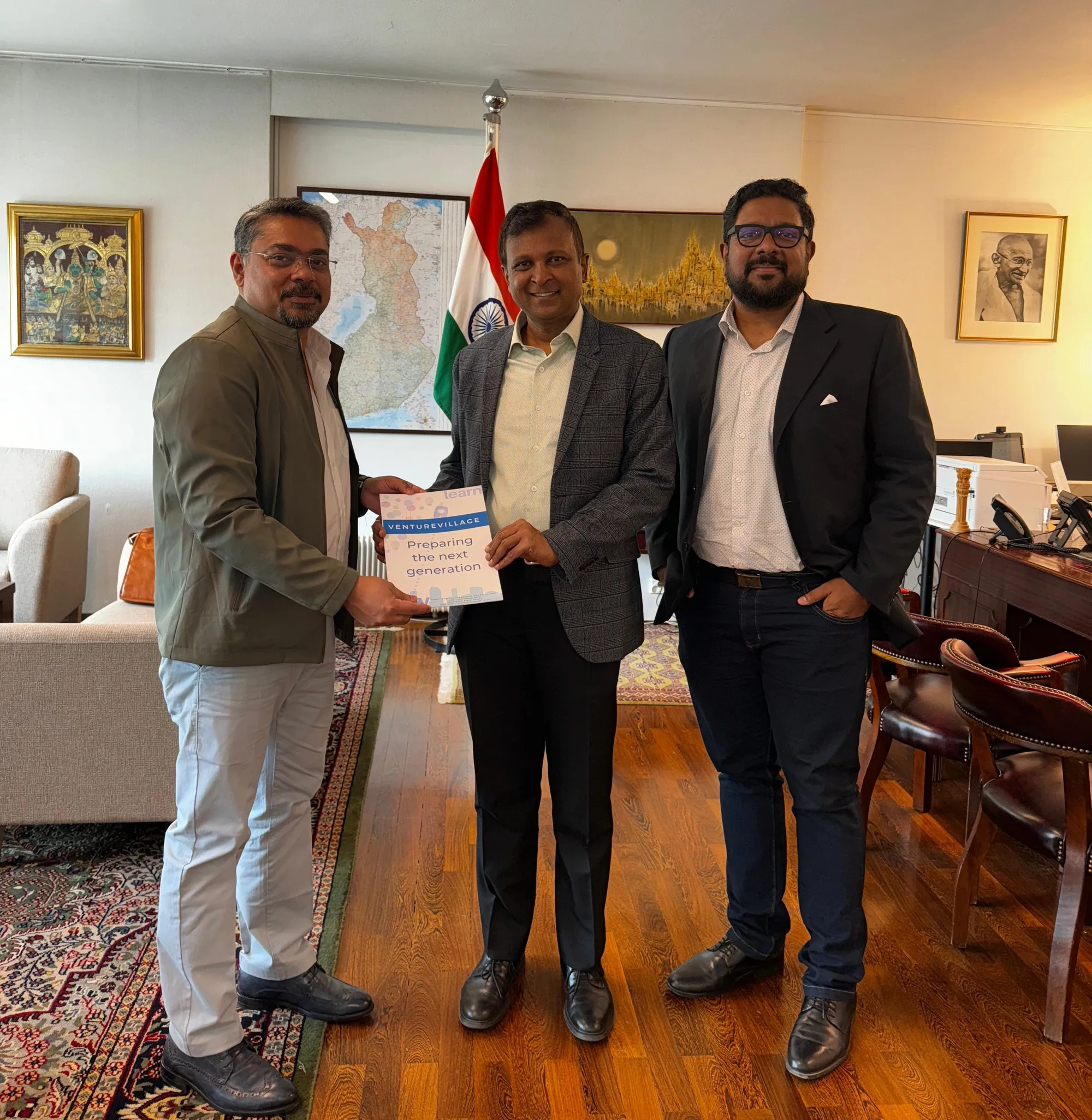 The VentureVillage founders with the Ambassador of India to Finland, Hemant H. Kotalwar, who is holding a VentureVillage brochure.
