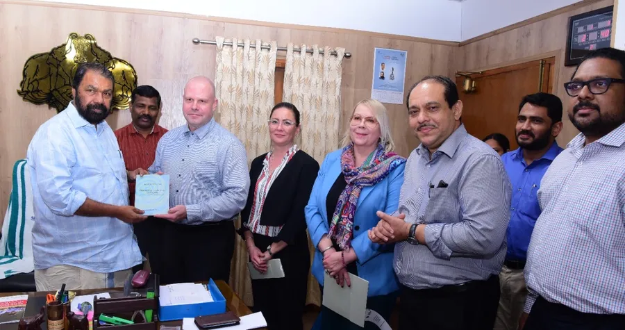 A Finnish delegation presents a book to Kerala’s Minister for General Education in his office.