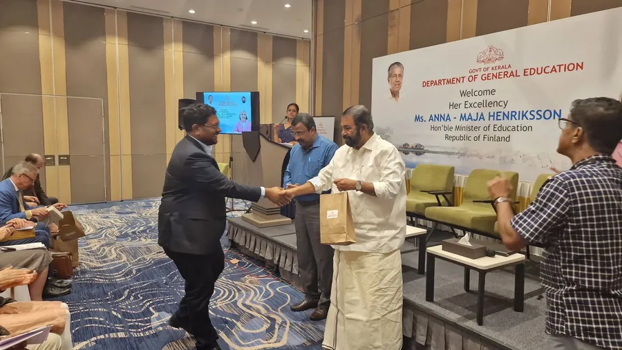 A VentureVillage co-founder receives a memento from Kerala’s Minister for General Education at an event welcoming Finland’s Minister of Education.