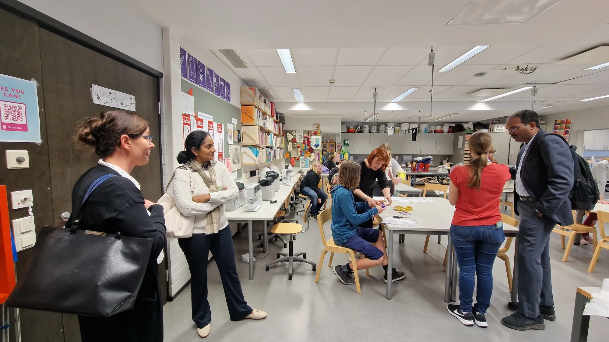 Delegation members watch students at work in a Finnish school's crafts classroom.
